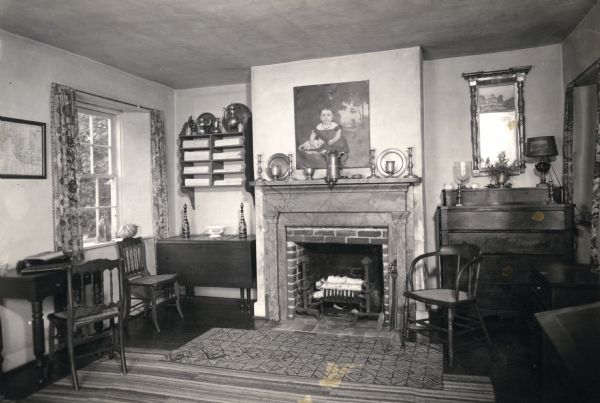 The restored limestone cottage, including a fireplace, desks, chairs and dresser, on Shake Rag Street called Pendarvis. The cottage was restored under the ownership of Robert M. Neal and Edgar Hellum and was used to serve Cornish tea and meals to guests by special reservation.