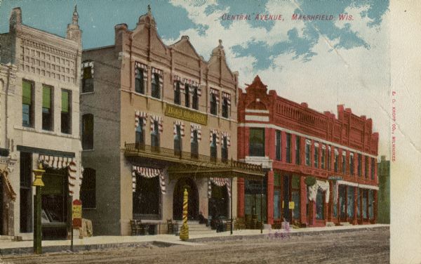 View across Central Avenue towards storefronts on the left. Caption reads: "Central Avenue, Marshfield, Wis."