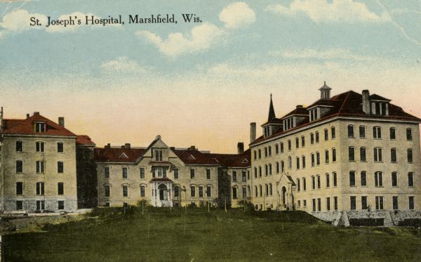 View across lawn towards the hospital. Caption reads: "St. Joseph's Hospital, Marshfield, Wis."