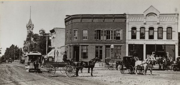 Looking west on to Public Square. There are horse-drawn vehicles and a streetcar in the foreground.