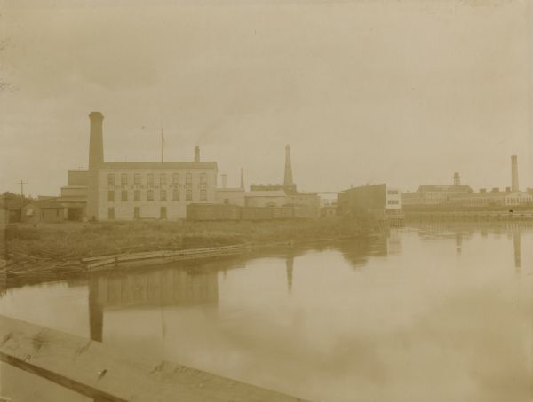 View across water towards a mill of the John Strange Paper Company.