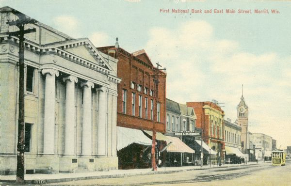 The First National Bank on East Main Street. In the distance is the Court House. Caption reads: "First National Bank and East Main Street, Merrill, Wis."