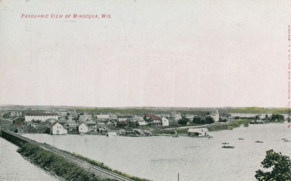 Caption reads: Panoramic View of Minocqua, Wis." A railroad bridge is in the foreground.