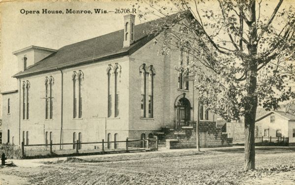 Exterior view towards the front and left side of the Opera House. Caption reads: "Opera House, Monroe, Wis."