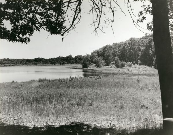 View of Ennis Lake, also known as Fountain Lake, located in the John Muir Memorial Park near Montello. As a boy, John Muir lived with his family on the shores of Fountain Lake from 1849-1857. Muir Park, which is owned by Marquette County, was named a State Natural Area in 1972, and Fountain Lake Farm was designated a National Historic Landmark on June 21, 1990.