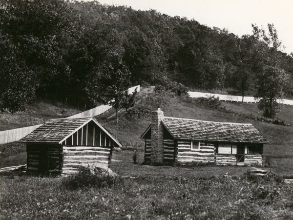 Exterior view of Little Norway buildings near a hill.