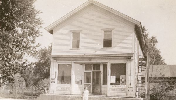 The Bradt Store, later destroyed by fire. A person is standing in front of the store.