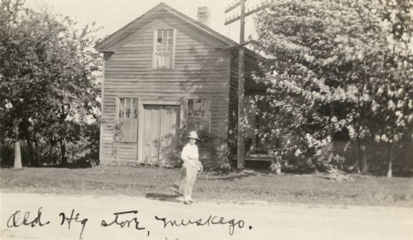 Ole Heg store, once also the home of Elias Stangeland (sp?). The original building was of log construction which was later boarded over. There is a woman standing in front of the store.