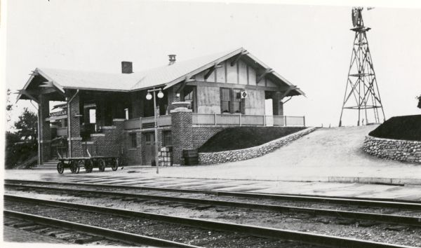 Chicago, Milwaukee, and St. Paul Railway depot. Side view of depot with windmill in background.