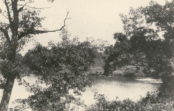 Nashotah Mission, Lewis Hall. View from a distance with lake in foreground and mission in background.