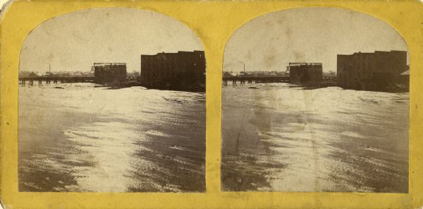 Stereograph of flour mill district. The Walnut Street bridge is in the background and the mill to the right is the Atlantic Mills (Neenah Stone Mills in 1870).