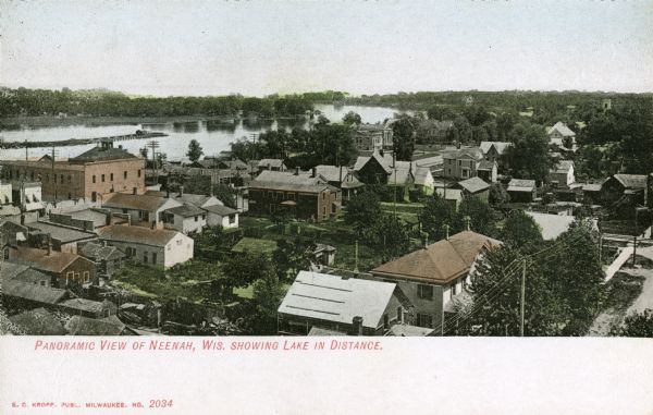 Panoramic elevated view over town, with a lake in the distance. Caption reads: "Panoramic View of Neenah, Wis. Showing Lake in Distance."