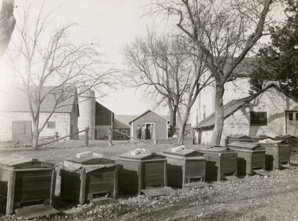Barn, smoke house, and bake house at Weiss farm, residence of John Weiss, in the township of Saukville, Ozaukee County, one half mile from County Trunk Hwy Y near Washington County line. Beehives are in a row in the foreground.