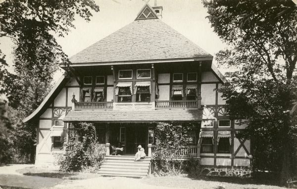 Waldheim Sanatorium, front view, with a woman sitting on the front porch steps.