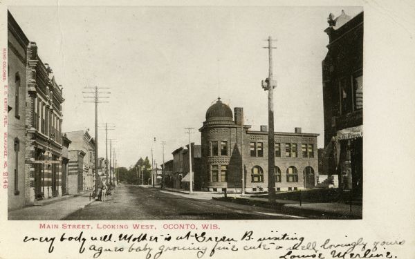 Main Street looking west. Horse-drawn buggy on street. Caption reads: "Main Street, Looking West, Oconto, Wis." 