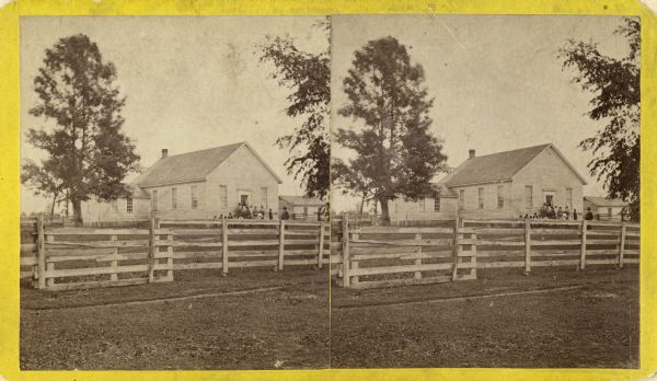 Stereograph of Presbyterian Mission school. People gathered in front of building. Fence in foreground of photograph.