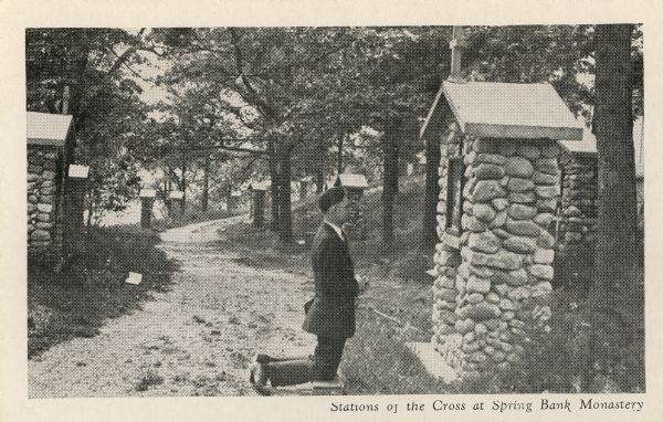 Spring Bank monastery. Man kneeling in from of one of the Stations of the Cross. This is probably part of the Cistercian monastery. Caption reads: "Stations of the Cross at Spring Bank Monastery".