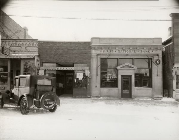View from street towards the First National Bank, and other store fronts.