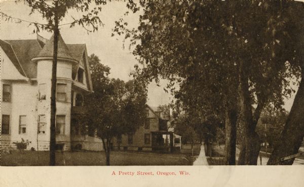A residential street in Oregon. The home in the left foreground belonged to, at the time of the photograph, the Sturgeon Family. The home is located on the west side of Main Street. Caption reads: "A Pretty Street, Oregon, Wis."