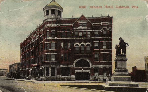 View across street towards the Athearn Hotel, located across the street from the Grand Opera House. Designed by the same man who designed the opera house, William Waters. There is a monument in the right foreground. Caption reads: "Athearn Hotel, Oshkosh, Wis."
