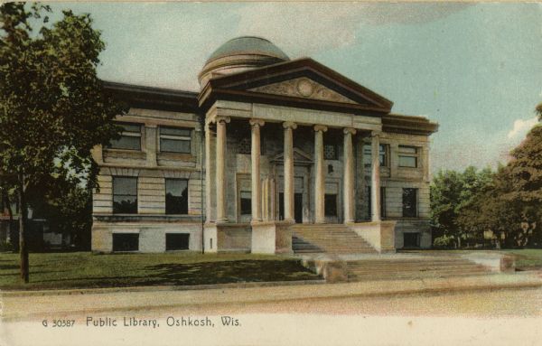 View across street towards the Oshkosh Public Library, located on Washington Avenue. The cornerstone was laid in May of 1899 and the library was finally complete in September of 1900. Caption reads: "Public Library, Oshkosh, Wis."