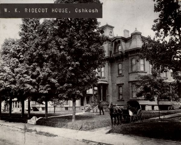 View from street towards the residence of W.K. Rideout. A horse-drawn carriage is in the driveway. Caption reads: "W. K. Rideout House, Oshkosh".