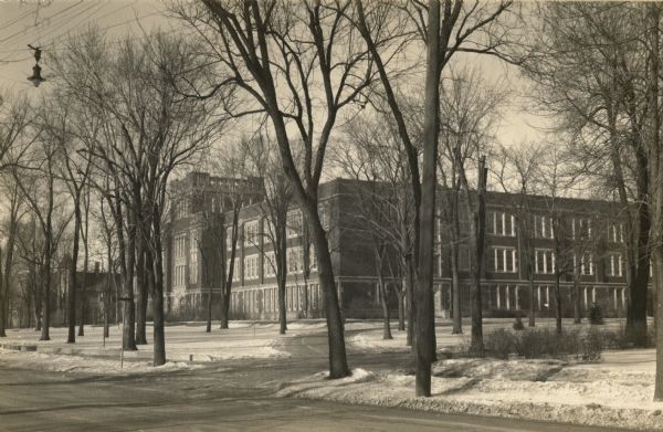 View from street of the main building of Oshkosh State Teachers College. Today this building is incorporated into the University of Wisconsin-Oshkosh. Snow is on the ground.