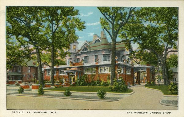 View from street of Stein's Shop. Caption reads: "Stein's, At Oshkosh, Wis." and "The World's Unique Shop." A colored postcard of the women's clothing store.