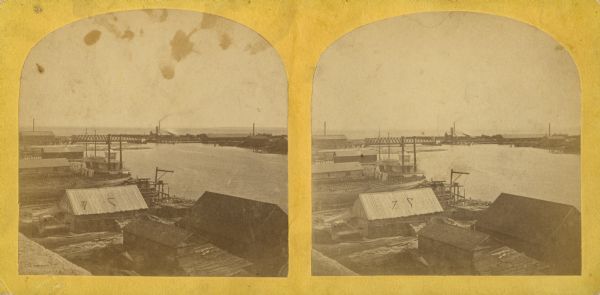 Stereograph of an elevated view of the lumbering industry on the Fox River. Lake Winnebago is in the background.