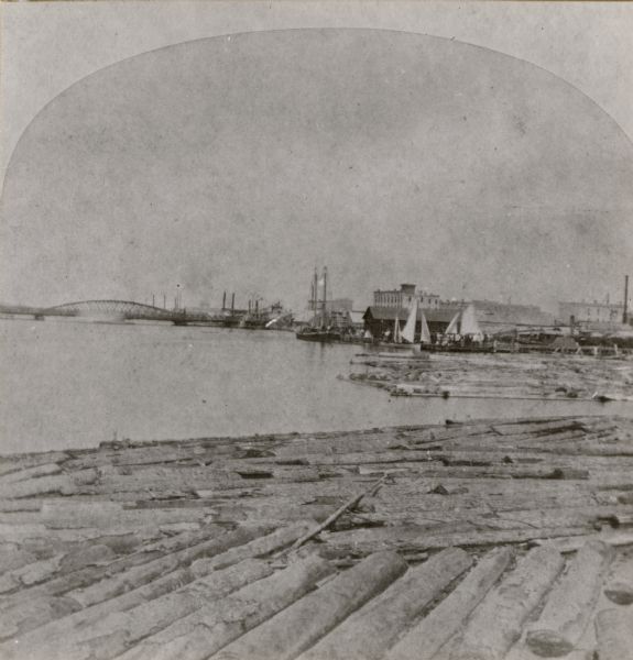 Stereograph of a sawmill area and Lake Winnebago in the foreground. The square building with the "cupola" was the Revere House. A manuscript notation, very faded, on the original photograph reads: "Frome's (?) sawmill, July 6, 1871, F.R. Haskill." The directories of this period do not list a Frome, Frame, or any name that looks vaguely like this.