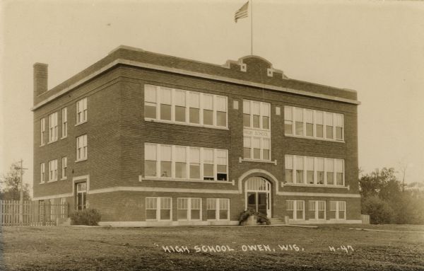 A view of the high school. Caption reads: "High School, Owen, Wis."
