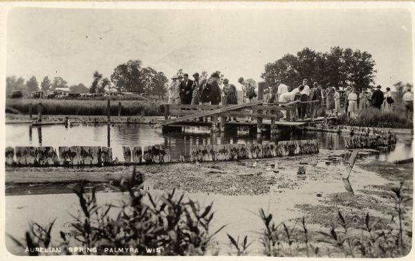 Palmyra Spring, called variously "Blue Spring" and  "Aurelian Spring". A group of people are standing on the pier. Caption reads: "Aurelian Spring Palmyra Wis".