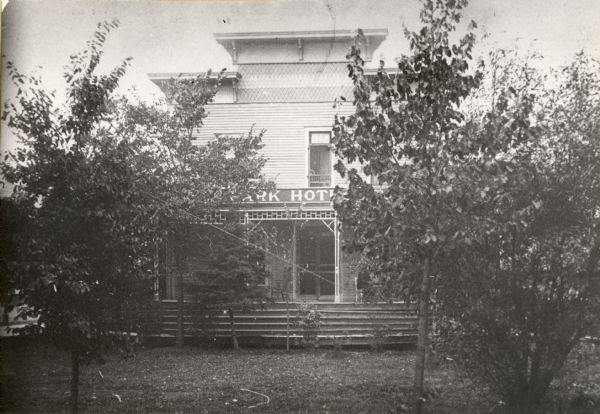 Front view of the Park Hotel, with an obstructed view, through trees, of the porch.