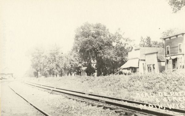 A view down the railroad tracks of the Chicago, Burlington, and Quincy Railroad Line. The depot is in the distance on the far left.