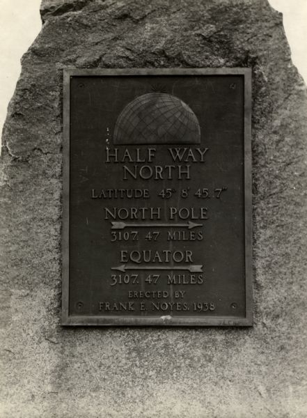 A view of a marker on highway 41 designating the half way point between the Equator and the North Pole.
