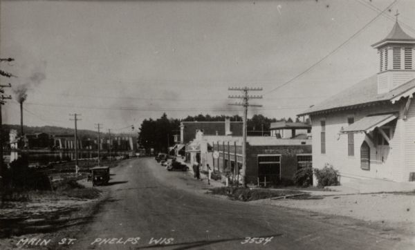 View looking down Main Street. Caption reads: "Main St. Phelps Wis".