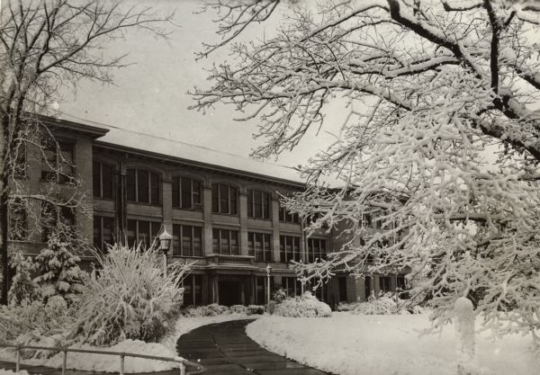 A view of the State Teacher's College. Snow is on the ground and covering the trees. The State Teacher's College and the Mining College in Platteville merged in the late 19th Century to become what is currently known as University of Wisconsin-Platteville.