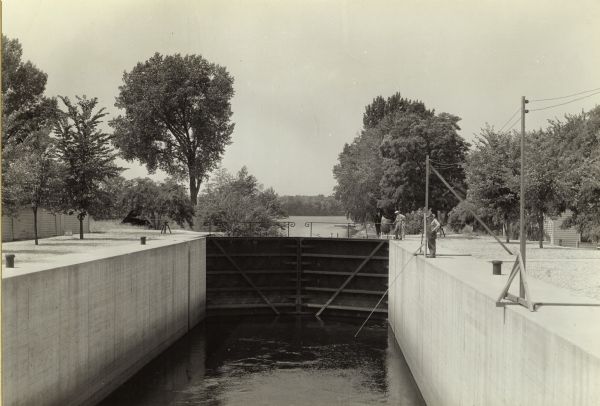 A view of the canal locks of the Portage Canal. Men are standing at the edge of the locks on the right.
