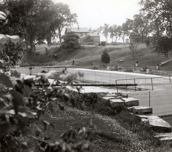 A view of the canal locks on the Fox River. The Indian Agency House is in the background on a hill.