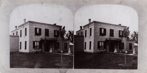 Stereograph of the Columbia County Jail. People are on the sidewalk near the entrance.