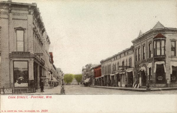 Colorized postcard of a view of Cook Street. Caption reads: "Cook Street, Portage, Wis."