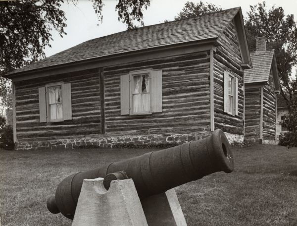 View of a cannon and two buildings at Fort Winnebago.