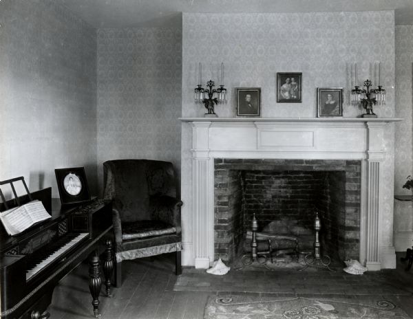 The Indian Agency House near the site of Fort Winnebago. Interior view of the parlor. The house served as residence for John and Juliette Kinzie after 1829 when he was appointed as federal Indian agent. She authored the book "Wau-bun," which gives an account of their lives here between 1830-1833. Their portraits are hanging over the mantle.