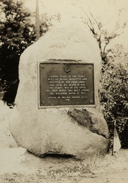 The Pierre Pauquette monument, located on the bank of the Wisconsin River where he operated a ferry between the years 1828 and 1836. Erected by the Wau-bun Chapter of the Daughters of the American Revolution, 1928.
