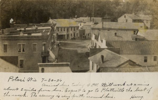 Elevated view over rooftops of town. Handwritten message reads: "Arrived here today 4 p.m. Will work at mines about 2 miles from here. Expect to go to Platteville the last of this week. The scenery is very pretty around here. Harry."
