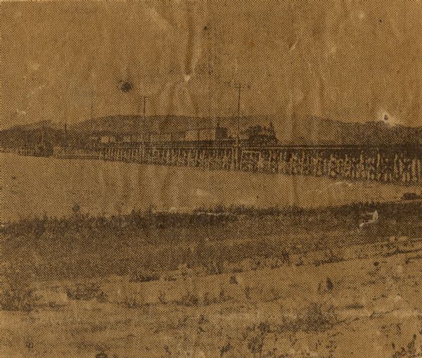 View from shoreline towards the bridge over the Mississippi River, built in 1874 and destroyed in 1910. Bluffs are in the background.