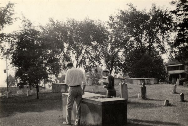 Fort Crawford Military Cemetery, restored by the United States Government about 1905. A man and woman are looking at a tomb in the foreground.
