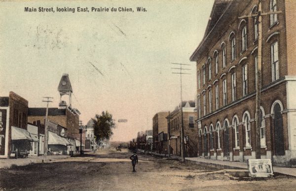 Caption reads: "Main Street, looking East. Prairie du Chien, Wis." View down street with a large building on the right.