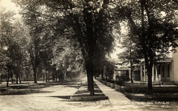 View of Minnesota Street, with a view down the right sidewalk with houses and trees.