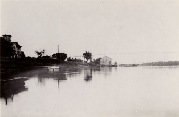 Mississippi River from the Brisbois Mansion. Left to right: Dousman House Hotel, railroad station, electrical plant smokestack, Diamond Jo warehouse, and a suspension automobile bridge, built in 1931, 90 feet above water level.